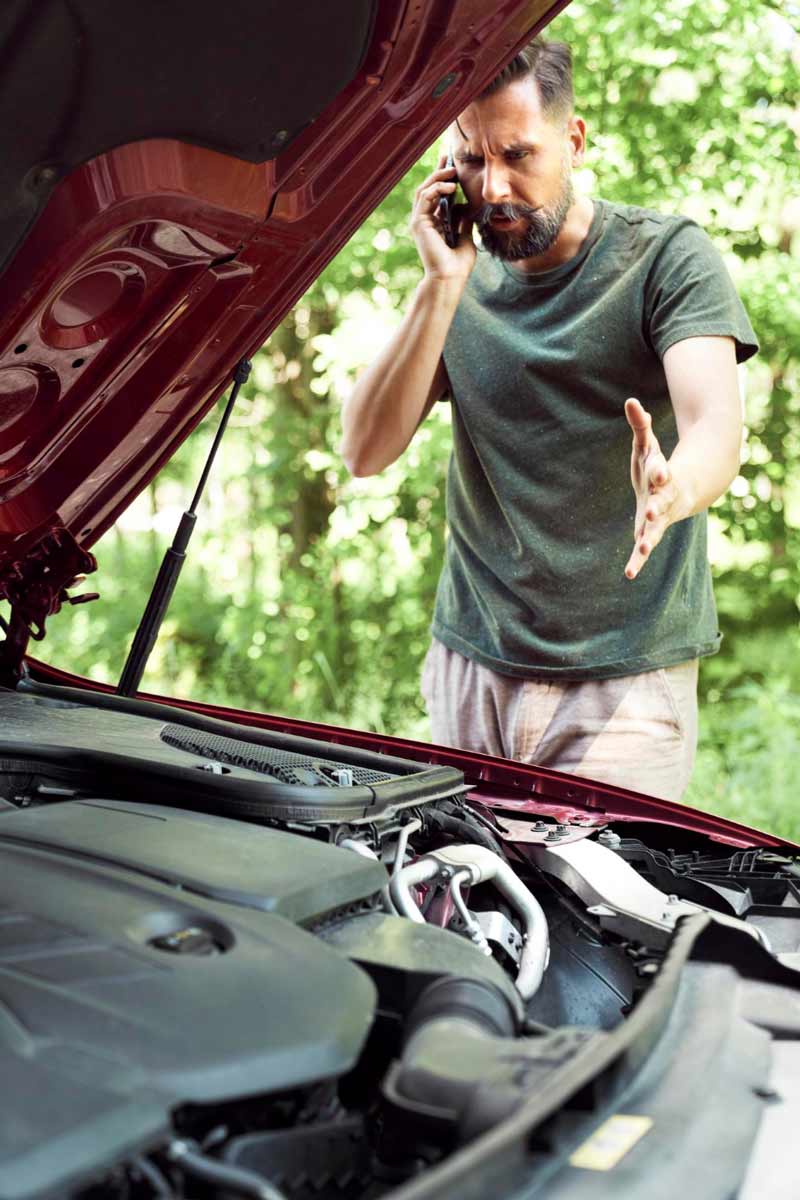 Junger Mann prüft Getriebeschaden bei Schrottauto Ankauf Glinde
